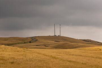 Communication tower in field with dark storm clouds