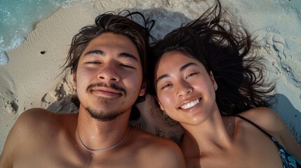 selfie portrait of an Asian heterosexual couple, laying on the sandy beach together sunbathing,