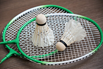 Two shuttlecocks lie on badminton rackets. Professional sports equipment. Game