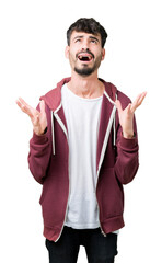Fototapeta premium Young handsome man over isolated background crazy and mad shouting and yelling with aggressive expression and arms raised. Frustration concept.