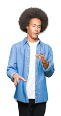 Young african american man with afro hair disgusted expression, displeased and fearful doing disgust face because aversion reaction. With hands raised. Annoying concept.