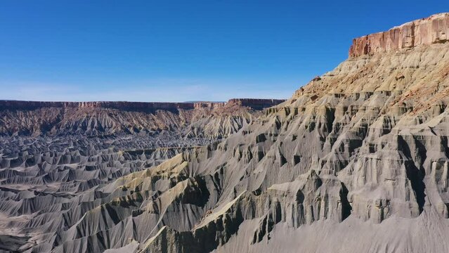 Amazing formations of steel blue smooth sharp rocks in mudstone canyon in desert in western Usa. Factory Butte and moonscape. Aerial view drone flying forward near the slope