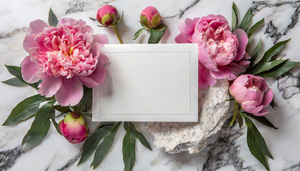Blank greeting card in frame made of pink peony flowers on white marble background. Wedding invitation. Mock up. Flat lay