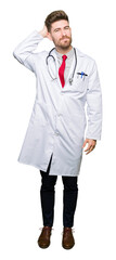 Fototapeta premium Young handsome doctor man wearing medical coat confuse and wonder about question. Uncertain with doubt, thinking with hand on head. Pensive concept.
