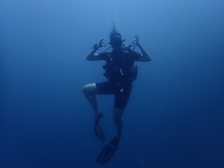 Fototapeta na wymiar scuba diver in the underwater, portrait, deep blue, chill and OK sign