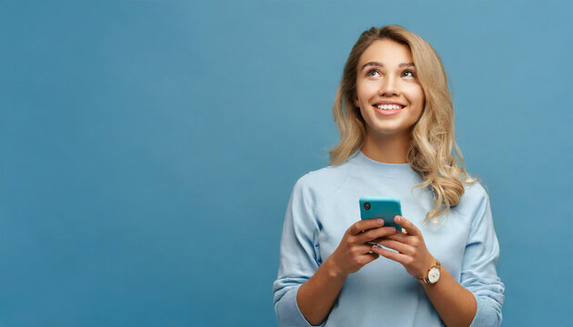 Young curious smiling happy pretty latin woman holding mobile phone, doing online shopping on cell, using apps on cellphone looking aside at copy space standing isolated on blue background