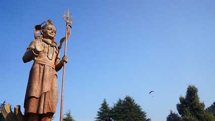 old statue of god shiv holding trishul