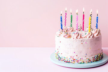 pink cake on a stand with burning candles on a pink background