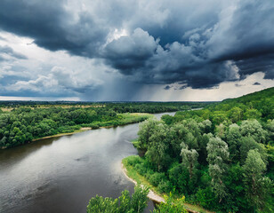 Fototapeta na wymiar Dense Raining clouds over the river in the green forest