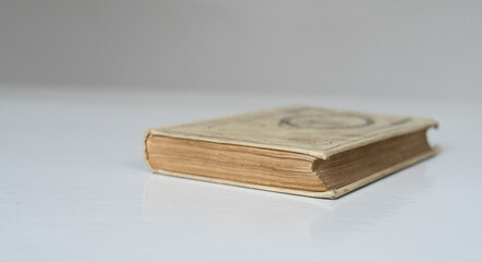Vieux livre fermé sur une table blanche