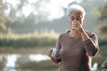 Positive senior women, grandmother, elderly Caucasian female is holding cup of coffee in the early...