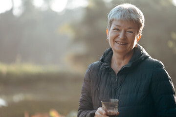Healthy grandmother with shot grey hair is drinking and enjoying coffee time in the morning with joyful, smile, inspiration, motivation and happy emotion. A portrait of female elderly with copy space.