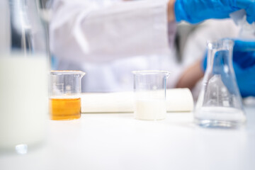 Milk sample in beaker or science equipment in laboratory, genetic, fat, glucose, nutrition, protein and lactose research. Experiment of dairy factory product quality control or analysis, biochemistry.