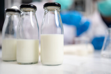 Milk sample in beaker or science equipment in laboratory, genetic, fat, glucose, nutrition, protein and lactose research. Experiment of dairy factory product quality control or analysis, biochemistry.
