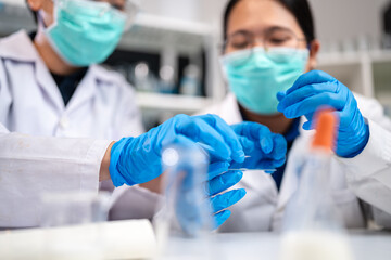 A Scientists or nutritionists are working on a sample of milk in biotechnology laboratory, genetic and bacteria research, dairy product quality control, protein, glucose and lactose percentage test.