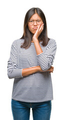 Young asian woman wearing glasses over isolated background thinking looking tired and bored with depression problems with crossed arms.