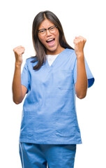 Young asian doctor woman over isolated background very happy and excited doing winner gesture with arms raised, smiling and screaming for success. Celebration concept.