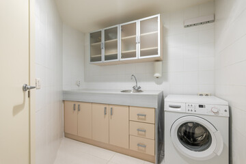Small laundry room with washing machine sink and storage cabinets