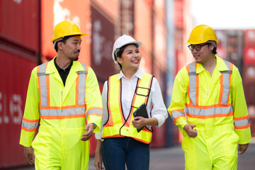 Group of engineers working with laptop in the container yard. This is a freight transportation and distribution warehouse.