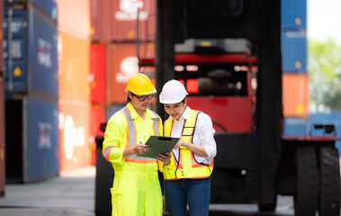 Portrait of Asian woman engineer and worker working with co-worker at overseas shipping container yard.