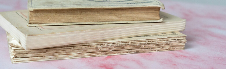 Fototapeta premium Pile de livres anciens sur une table en marbre rose - vieux livres empilés