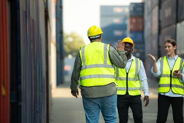 Group of workers in a container storage yard greeting each other during breaks in front of...