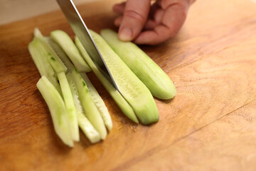 Fresh cucumber is cut into pieces for cooking. Cooking cucumber dishes