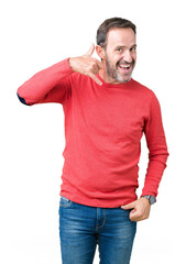 Fototapeta premium Handsome middle age hoary senior man wearing winter sweater over isolated background smiling doing phone gesture with hand and fingers like talking on the telephone. Communicating concepts.