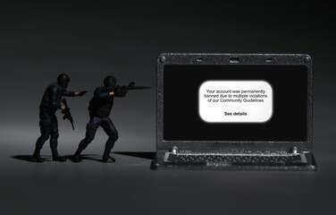 A picture of soldier miniature with laptop showing Community Guidelines warning in low light.