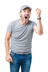 Handsome middle age hoary senior man wearing sport cap over isolated background angry and mad raising fist frustrated and furious while shouting with anger. Rage and aggressive concept.