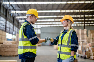 workers man and woman engineering walking and handshakeing with working suite dress at warehouse. Concept of smart industry worker operating. Wood factories produce wood palate