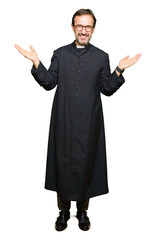 Middle age priest man wearing catholic robe Smiling showing both hands open palms, presenting and advertising comparison and balance