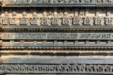 Beautiful intricate patterns and carvings of figurines on the wall of the ancient Chennakeshava temple in Belur, Karnataka.