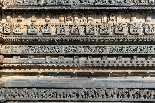 Beautiful intricate patterns and carvings of figurines on the wall of the ancient Chennakeshava temple in Belur, Karnataka.
