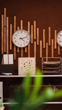 Vertical Video Empty front desk and lobby at luxurious vacation resort with clocks showing different international time zones. Modern reception and lounge area ready for guests and travelers