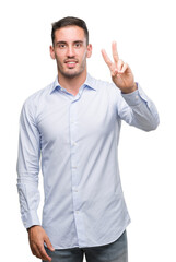 Handsome young businessman smiling looking to the camera showing fingers doing victory sign. Number two.