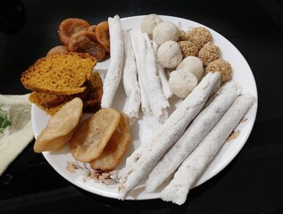 Assamese food known as pitha and laru prepared during Bihu festival in Assam. Laru is prepared with coconut and sesame seeds. Pitha is prepared with rice flour and other ingredients.