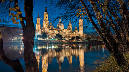 Evening Radiance: Zaragoza's skyline adorned with the Basilica del Pilar, a crescent moon, and the...