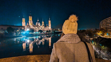 Zaragoza's Night: A captivating silhouette faces the illuminated Basilica del Pilar, Ebro River,...