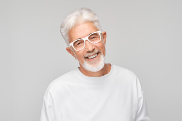 Portrait gray-haired man smiling joyfully with happy face isolated on white studio background,...