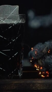 the bartender behind the bar makes a black unusual alcoholic cocktail, a very beautiful drink in a nightclub, expensive alcohol in a glass of a luxury restaurant