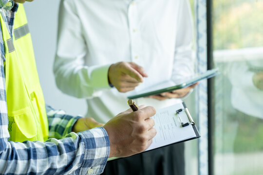 inspector or engineer is inspecting construction and quality assurance new house using a checklist. Engineers or architects or contactor work to build the house before handing it over to the homeowner