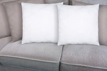 Fototapeta na wymiar Two White Throw Pillows Mockup Styled on Beige Living Room Sofa