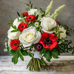 bouquet of flowers with white roses, red anemones, and greenery