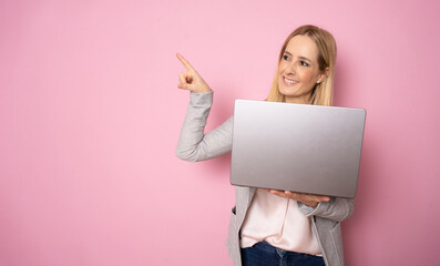 Beautiful young woman working using computer laptop over pink background cheerful with a smile on...