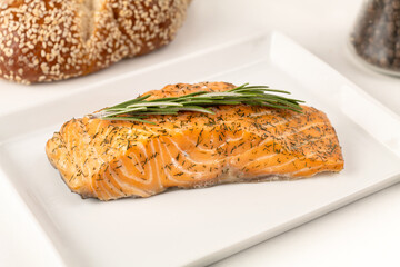 Geräucherter Lachsstreifen mit Dill angerichtet auf einem weißen Teller