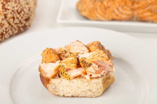 Halbes Sesambrötchen belegt mit geräuchertem Lachs