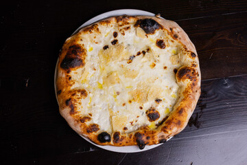 Pizza tradizionale napoletana ai quattro formaggi servita in una pizzeria - obrazy, fototapety, plakaty