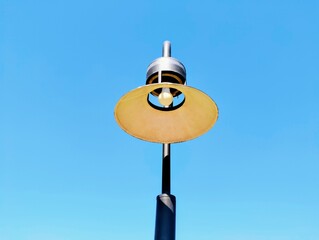 The sky in the background in the middle of the picture is an antique lamp, the pole and the lamp shade outside are black, beautiful and striking in the style of an old lamp that has been in use for ma