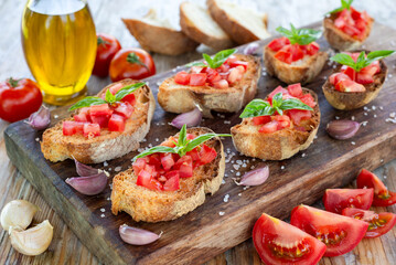Bruschette con pomodori freschi, aglio, olio di oliva, sale e basilico, tipici antipasti italiani, dieta mediterranea 